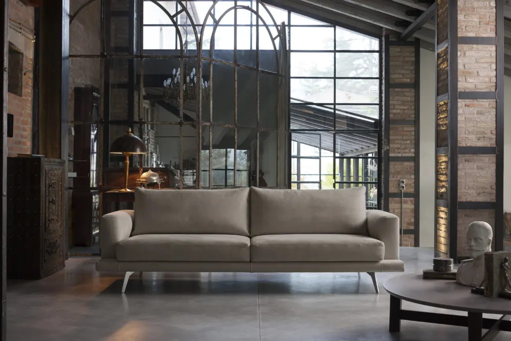 Divano in tessuto chiaro in un loft industriale